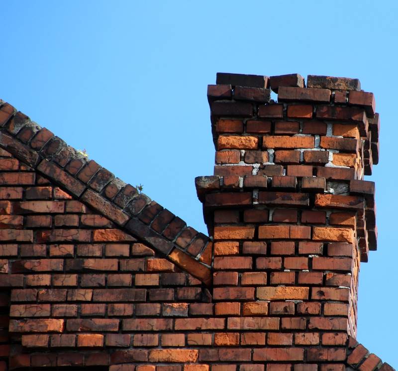 Damaged chimney on an Posen home showing cracks and missing mortar